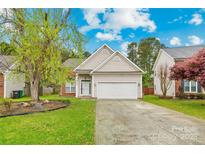 Charming home featuring neutral siding, a two-car garage, and a well-manicured front lawn at 13521 Michael Lynn Rd, Charlotte, NC 28278