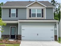 Two-story home with gray siding, stone accents, a two-car garage, and a well-maintained lawn at 1530 Doran Ter, Richburg, SC 29729