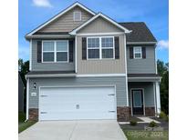 Two-story home featuring a two-car garage, stone accents, and coordinated gray and tan siding at 1564 Doran Ter, Richburg, SC 29729