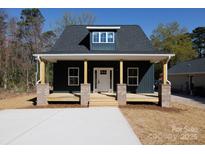Charming home features a welcoming front porch with brick pillars and a well-manicured lawn at 202 Westerwood Dr, Rock Hill, SC 29732