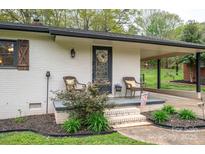 Attractive front porch with brick accents, comfortable wicker seating, and manicured landscaping at 706 Annieline Dr, Shelby, NC 28152