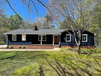Charming single story home with a dark blue facade, brick foundation, inviting front porch, and lush green lawn at 923 Wyke Rd, Shelby, NC 28150