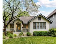 Charming cottage-style home with a well-maintained lawn and inviting front porch with beautiful flowers at 925 E 35Th St, Charlotte, NC 28205