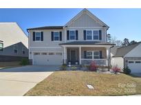 Charming two-story home with a well-manicured lawn, attached garage and inviting front porch at 966 Scotch Meadows Loop, Monroe, NC 28110