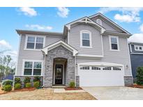Charming two-story home with gray siding, stone accents, a two-car garage, and a well-maintained front yard at 9934 Cask Way, Huntersville, NC 28078
