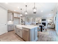 Open-concept kitchen with a large island, stainless steel appliances, and seamless connection to the dining and living area at 9938 Cask Way, Huntersville, NC 28078