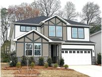 Two-story home boasts white siding, gray trim, stone accents, and a two-car garage at 9957 Cask Way, Huntersville, NC 28078