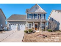 Charming two-story home featuring a two-car garage, well-maintained lawn, and inviting front entrance at 12848 Mustang Dr, Midland, NC 28107