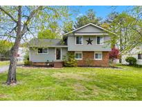 Charming two-story home with a combination of brick and siding, complemented by a well-maintained lawn and mature trees at 1308 Gaston Way, Dallas, NC 28034
