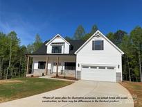 Inviting two-story home featuring a two car garage, black shutters, stone accents, and an immaculate lawn at 154 Carters Farm Dr, Statesville, NC 28625