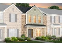 Charming townhome featuring a brick facade, inviting front entrance, and well-manicured landscaping at 2222 Cobble Ct # 156, Monroe, NC 28110