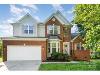 Charming two-story brick home featuring a two-car garage and well-manicured front lawn at 2514 Waters Vista Cir, Charlotte, NC 28213