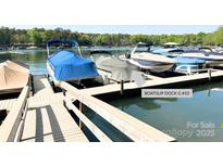 View of boat slip dock with multiple boats covered with blue, brown, and gray colored covers at 4599 Rustling Woods Dr, Denver, NC 28037
