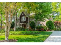 Charming brick home with lush landscaping, mature trees, and well-maintained lawn at 4599 Rustling Woods Dr, Denver, NC 28037