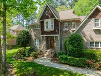 Charming two-story brick home with a beautiful manicured lawn and lush landscaping at 4599 Rustling Woods Dr, Denver, NC 28037