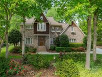Traditional brick home featuring mature landscaping, a bay window, and a welcoming front entrance at 4599 Rustling Woods Dr, Denver, NC 28037