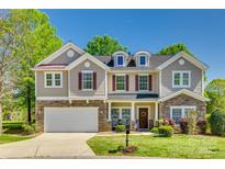 Charming two-story home with stone accents, neutral siding, and a well-manicured front lawn at 722 Sandy Green Ct, Fort Mill, SC 29715
