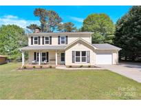 Charming two-story home with black shutters, a spacious front yard, and an attached garage at 1308 Spring Lake Dr, Gastonia, NC 28054