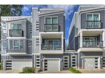 Modern townhome exterior featuring balconies, gray siding, and attached garages for convenient parking at 1651 Duckworth Ave, Charlotte, NC 28208