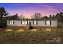 Charming single-story home with brick foundation, wood siding, and a lush, landscaped yard at 2154 Withers Dr, Maiden, NC 28650