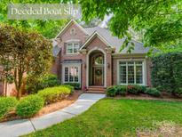 Charming brick home featuring mature landscaping, a well-manicured lawn, and an inviting entrance with a beautiful arched doorway at 4646 Eagle Pointe Ct, Denver, NC 28037