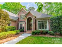 Charming brick home featuring an arched entryway, well-maintained landscaping, and a welcoming front porch at 4646 Eagle Pointe Ct, Denver, NC 28037