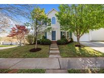 Charming two-story home with a well-manicured lawn, inviting walkway, and vibrant landscaping at 7262 April Mist Trl, Huntersville, NC 28078