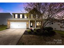 Charming two-story brick home with a well-manicured lawn and attached two-car garage at 10773 Sapphire Trl, Davidson, NC 28036