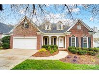Charming brick home featuring manicured landscaping, inviting entryway, and two-car garage at 1509 Burning Lantern Ln, Kannapolis, NC 28081