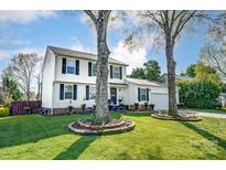 Charming two-story home with classic white siding, black shutters, and well-manicured lawn with mature trees at 2243 Flint Glenn Ln, Charlotte, NC 28262