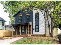 Charming two-story home with a modern exterior and inviting front porch perfect for relaxing and enjoying the neighborhood at 411 Cemetery St, Charlotte, NC 28216