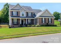 Charming two-story brick home with well-manicured lawn, black shutters and covered front porch at 706 Springwood Dr # 14, Waxhaw, NC 28173