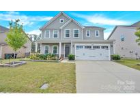 Charming two-story home featuring a well-manicured lawn, flower beds, and an attached two-car garage at 7278 Waterwheel St, Concord, NC 28025