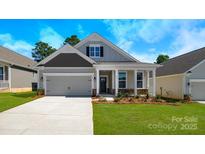 Charming one-story home featuring a covered front porch, two-car garage, and manicured lawn at 115 S Shayna Rd, Troutman, NC 28166