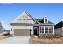 Charming single-story home showcasing a gray color scheme, a two-car garage, and a welcoming front entrance at 122 N Shayna Rd, Troutman, NC 28166