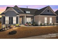 Charming single-Gathering home featuring stone accents, manicured landscaping, and a welcoming front entrance with dark shutters at 12709 Messenger Row, Huntersville, NC 28078