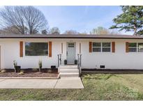 Charming single-story home with a white brick exterior, updated windows, and a well-manicured lawn at 1315 Vickie Ln, Matthews, NC 28104