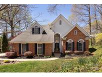 Charming brick home with manicured lawn, black shutters, arched windows, and a welcoming front entrance at 15327 Rush Lake Ln, Huntersville, NC 28078