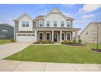 Inviting two-story home with a manicured lawn, covered porch, and attached two-car garage at 19412 Bird Meadow Dr, Huntersville, NC 28078