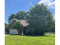 Traditional brick home with an attached garage, manicured lawn, and mature trees providing shade at 201 Fancy Lady Ct, York, SC 29745