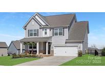 Charming two-story home with light gray siding, white trim, and an attached two-car garage in a desirable neighborhood at 3013 Whipcord Dr, Waxhaw, NC 28173
