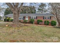 Charming red brick home featuring a well-maintained lawn, a porch swing and mature shade tree at 3509 Havenwood Rd, Dallas, NC 28034