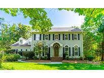Charming two-story home with a manicured lawn, mature trees, and classic architectural details at 5232 Silchester Ln, Charlotte, NC 28215
