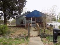 View of the home's exterior, featuring blue siding and an enclosed porch at 526 Peaceful Leaf Ln, Kings Mountain, NC 28086