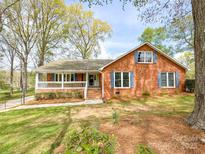 Traditional brick home with a welcoming front porch and eye-catching blue shutters at 12011 Stoney Meadow Dr, Mint Hill, NC 28227