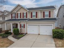 Charming two-story home featuring a two-car garage, red shutters, and well-maintained landscaping at 125 Colville Rd, Mooresville, NC 28117