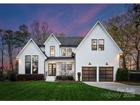 Stunning two-story modern farmhouse with black-framed windows and a manicured lawn at twilight at 209 Sardis Ln, Charlotte, NC 28270