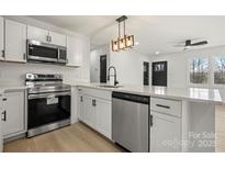 Bright kitchen features stainless steel appliances, white cabinets, and a quartz countertop at 2120 Green Oak Dr, Shelby, NC 28152