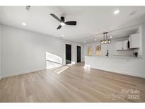 Open floor plan with new floors, a ceiling fan, and views into the modern kitchen at 2120 Green Oak Dr, Shelby, NC 28152