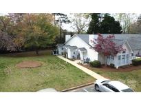 Charming single-story home with well-manicured lawn, welcoming front porch, and cozy seating area at 21205 Cold Spring Ln, Cornelius, NC 28031